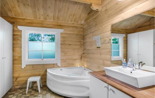 a bathroom with a white tub and a sink at Stunning Home In Rnne With Wifi in Hasle