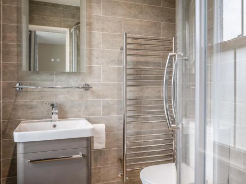 a bathroom with a sink and a toilet and a shower at 1 Top View Cottages in Salcombe
