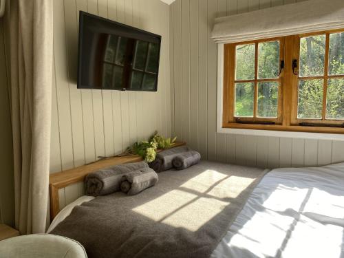 1 dormitorio con 1 cama y TV en la pared en Kingfisher en Chirk