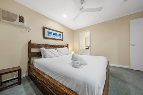a bedroom with a large bed with white sheets at Pet Friendly Family Home with Pool Close to Theme Parks in Gold Coast