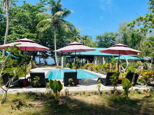 una piscina con sombrillas y sillas y un complejo en Koh Jum Delight Beach, en Ko Jum