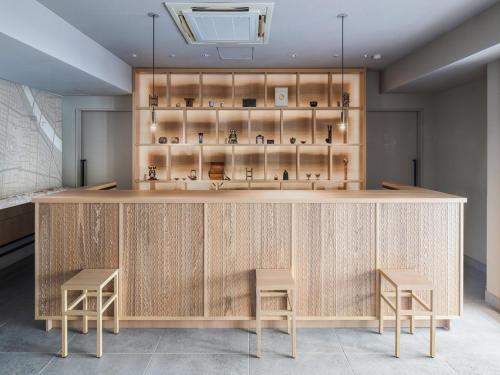 a counter in a room with two stools at Vessel Inn Asakusa Tsukuba Express in Tokyo