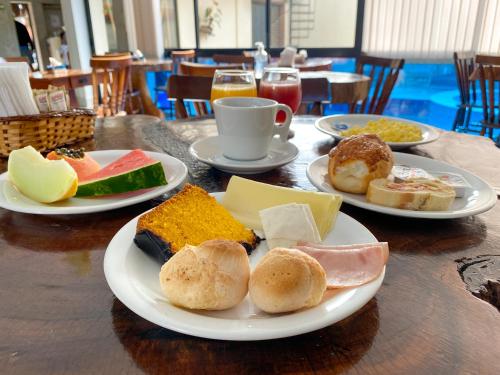 ein Tisch mit Tellern voller Essen auf einem Tisch in der Unterkunft Pousada Ubuntu in Ubatuba