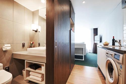 a bathroom with a sink and a washing machine at Jeju Pureun Hotel in Seogwipo