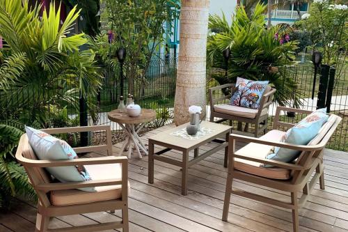 a patio with three chairs and a table and a table at TiSucrier Orient Bay Ocean Front in Orient Bay