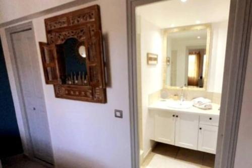a bathroom with a sink and a mirror at TiSucrier Orient Bay Ocean Front in Orient Bay