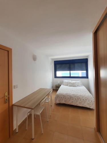 a bedroom with a bed and a wooden table at Roseville in Puerto del Rosario