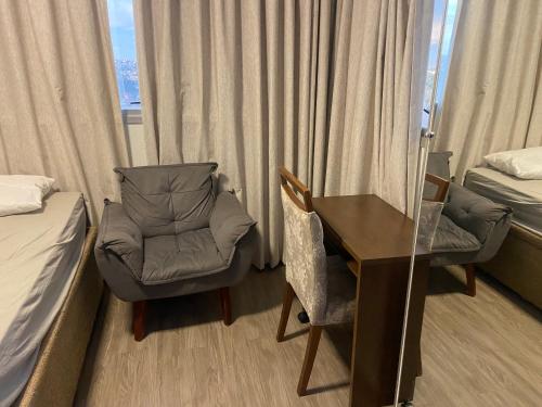 a room with a desk and a chair and a bed at Hotel Taguatinga Flat - conforto e requinte - Apto 416 in Brasilia
