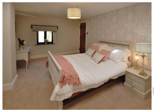 a bedroom with a large bed and a desk at Church Farm in Little Cawthorpe