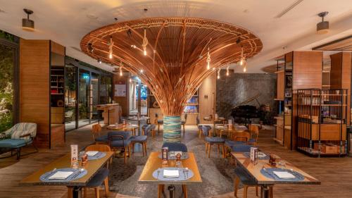 a restaurant with tables and chairs and a piano at Hotel Indigo Phuket Patong by IHG in Patong Beach