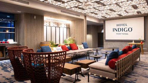 a hotel lobby with chairs and tables and a screen at Hotel Indigo Phuket Patong by IHG in Patong Beach