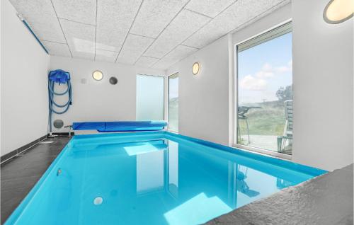 a large swimming pool with blue water in a room at Stunning Home In Thisted With Sauna in Klitmøller