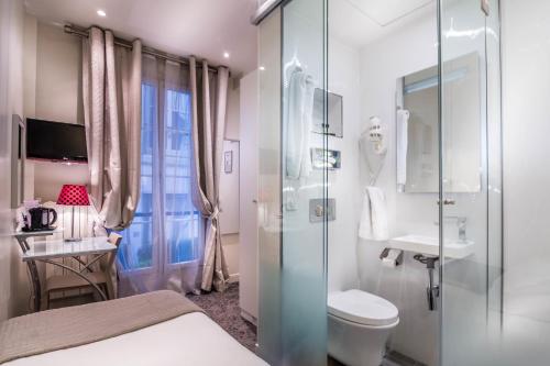 La salle de bains est pourvue d'une douche, de toilettes et d'un lavabo. dans l'établissement Hotel Ascot Opera, à Paris