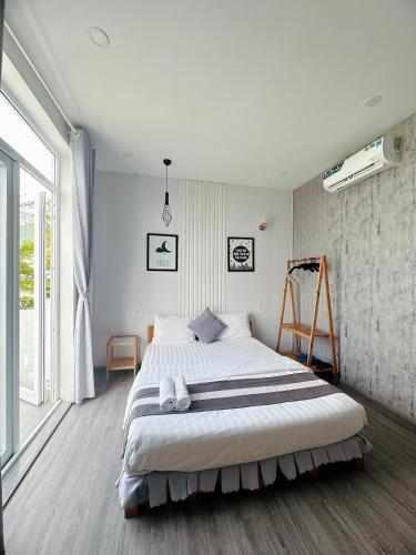 a bedroom with a large bed and a large window at Sele House in Ha Tien