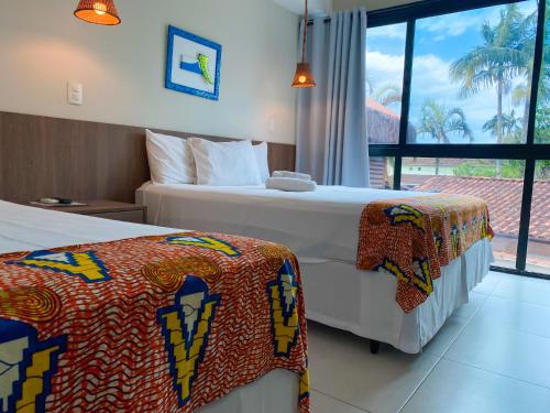 um quarto de hotel com duas camas e uma janela em Pousada Ubuntu em Ubatuba