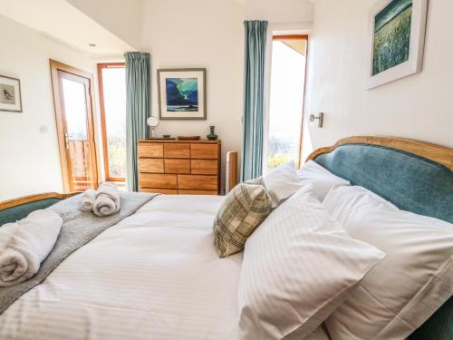 a bedroom with a white bed with towels on it at Balvaig in Pitlochry