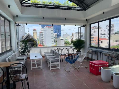 a patio with chairs and tables and windows at Lemon House in Quy Nhon