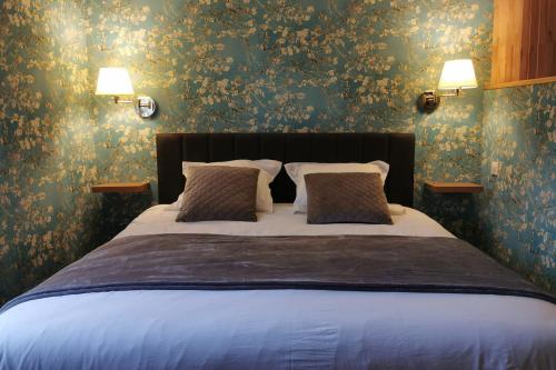 1 dormitorio con 1 cama grande y papel pintado con motivos florales en Appart Deluxe - Centre historique LIMOGES, en Limoges