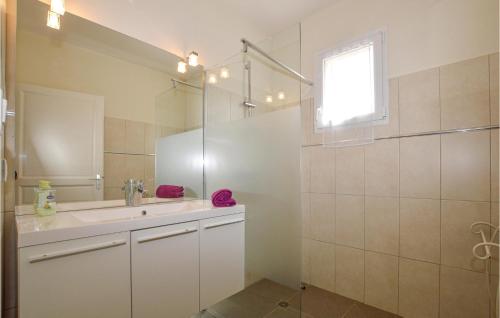 La salle de bains est pourvue d'un lavabo, d'une douche et d'un miroir. dans l'établissement 3 Bedroom Stunning Apartment In Petreto-biccisano, à Petreto-Bicchisano