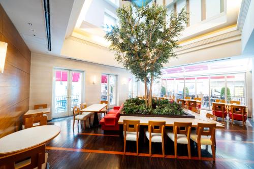 a restaurant with tables and chairs and a tree at KOKO HOTEL Osaka Shinsaibashi in Osaka