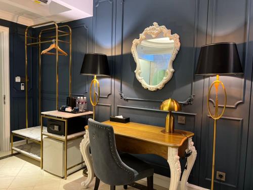 a desk with two lamps and a mirror on a wall at Grand Eska Hotel & Suites Batam in Nagoya