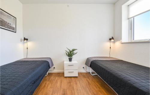 2 camas en una habitación con paredes blancas en Lovely Home In Ringkbing With House A Panoramic View, en Søndervig