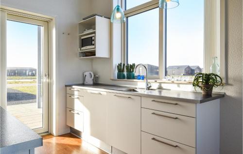 uma cozinha branca com um lavatório e uma janela em Awesome Home In Ringkbing With 3 Bedrooms And Wifi em Søndervig