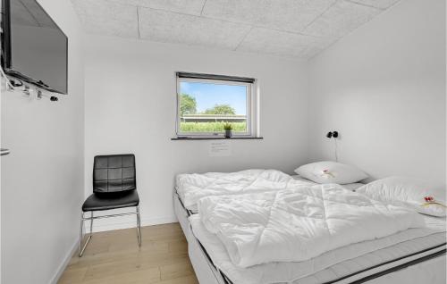 ハザスレウにあるStunning Home In Haderslev With 4 Bedrooms, Sauna And Wifiの白いベッドルーム(ベッド1台、椅子付)
