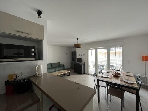 une cuisine et un salon avec une table et des chaises dans l'établissement Appartement T3 de 66m² avec terrasse, parking et proche jetée Thiers, centre-ville d'Arcachon - FR-1-374-209, à Arcachon