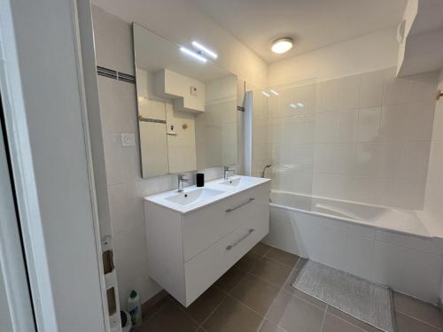 une salle de bain blanche avec un lavabo et une baignoire dans l'établissement Appartement T3 de 66m² avec terrasse, parking et proche jetée Thiers, centre-ville d'Arcachon - FR-1-374-209, à Arcachon