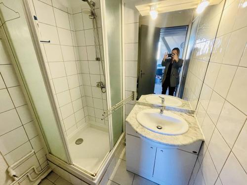 une personne prenant une photo d'une salle de bains avec lavabo dans l'établissement Studio moderne proche plage, climatisé, terrasse, parking inclus - Cap d'Agde - FR-1-723-98, au Cap d'Agde