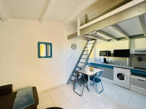 - une cuisine avec une table et un escalier dans une chambre dans l'établissement Studio moderne proche plage, climatisé, terrasse, parking inclus - Cap d'Agde - FR-1-723-98, au Cap d'Agde