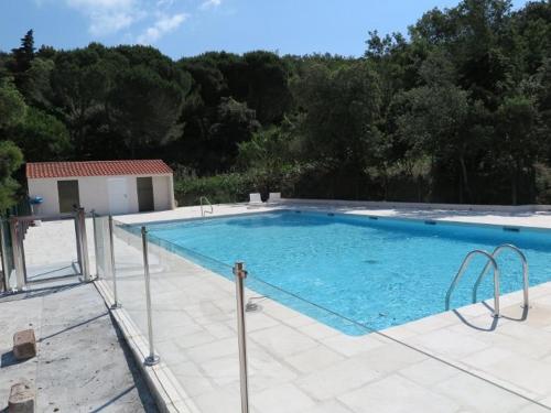 une grande piscine installée à côté d'une maison dans l'établissement Splendide appartement avec piscine et jardin face à la mer - FR-1-726-2, à La Croix-Valmer