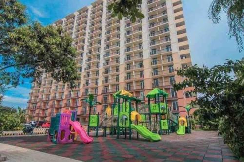 a playground in front of a large building at Condo Stay at Saekyung Looc in Lo-oc