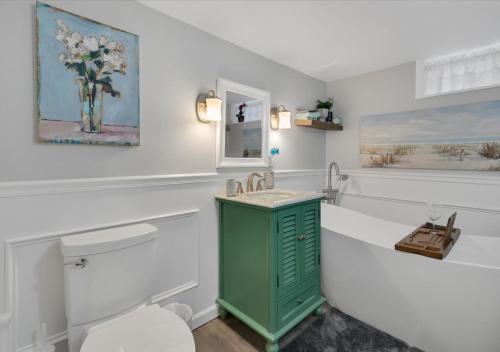 La salle de bains est pourvue d'un meuble vert à côté des toilettes. dans l'établissement Sunset Cove, à East Hampton