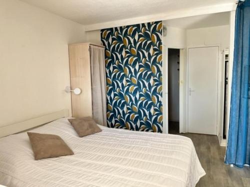 - une chambre dotée d'un lit avec un mur bleu et jaune dans l'établissement Mas rénové 4 pers, terrasse, piscine, proche plages - FR-1-726-4, à La Croix-Valmer