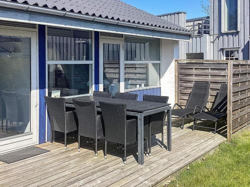 a black table and chairs on a wooden deck at 5 person holiday home in V ggerl se in Bøtø By