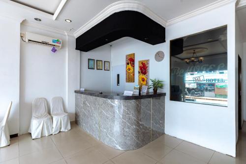 a bar in a room with two white chairs at Urbanview Hotel Crystal Nagoya Batam by RedDoorz in Batam Center