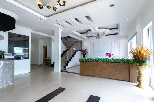 a lobby of a house with flowers in the middle at Urbanview Hotel Crystal Nagoya Batam by RedDoorz in Batam Center