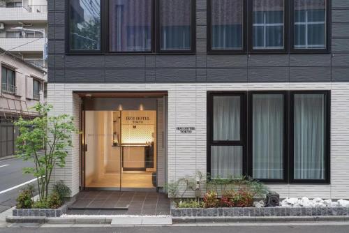 a black and white building with a glass door at Tokyo IKOI HOTELー綺麗なホテル in Tokyo