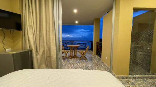 a bedroom with a bed and a view of the ocean at Cabañas Paraiso in Taganga