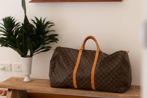 a bag sitting on a table next to a plant at The Little House in Byron Bay