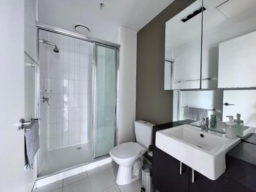 a bathroom with a toilet and a sink and a shower at MelbCBD Central NYE Fireworks large 3BR2BTH GymPool in Melbourne