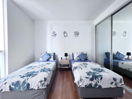 ein Schlafzimmer mit zwei Betten und einem Spiegel in der Unterkunft MelbCBD Central large 3BR2BTH GymPool Heater in Melbourne