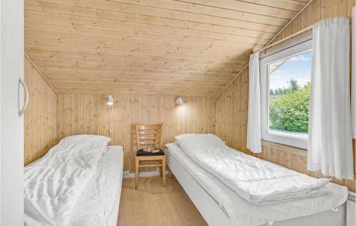 two beds in a small room with a window at Stunning Home In Vggerlse With Sauna, Wifi And Indoor Swimming Pool in Bøtø By