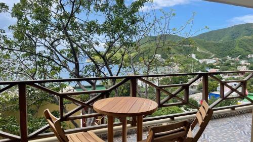 a table and chairs on a balcony with a view at Cabañas Paraiso in Taganga