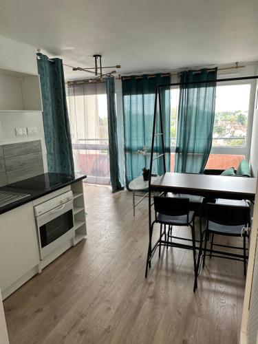 une cuisine et une salle à manger avec une table et des chaises dans l'établissement Studio cosy, à Le Mée-sur-Seine