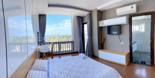 - une chambre avec un lit et une grande fenêtre dans l'établissement Vũng Tàu Apartmen OSC, à Vung Tau