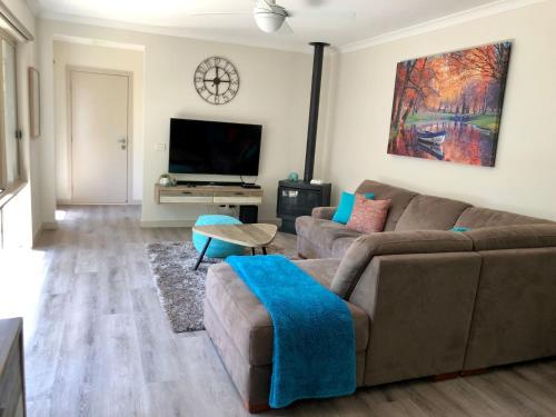 a living room with a couch and a flat screen tv at Bright Delight in Bright