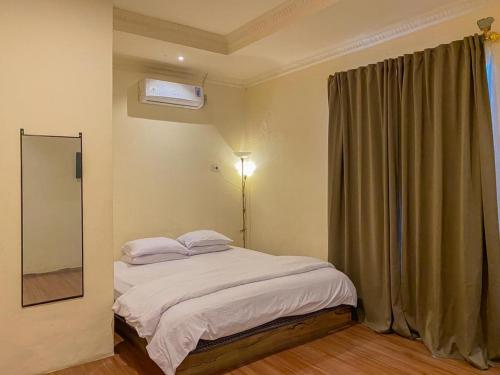 Schlafzimmer mit einem Bett und einem Fenster mit einem Spiegel in der Unterkunft Urbanview Hotel ME Jayapura in Jayapura
